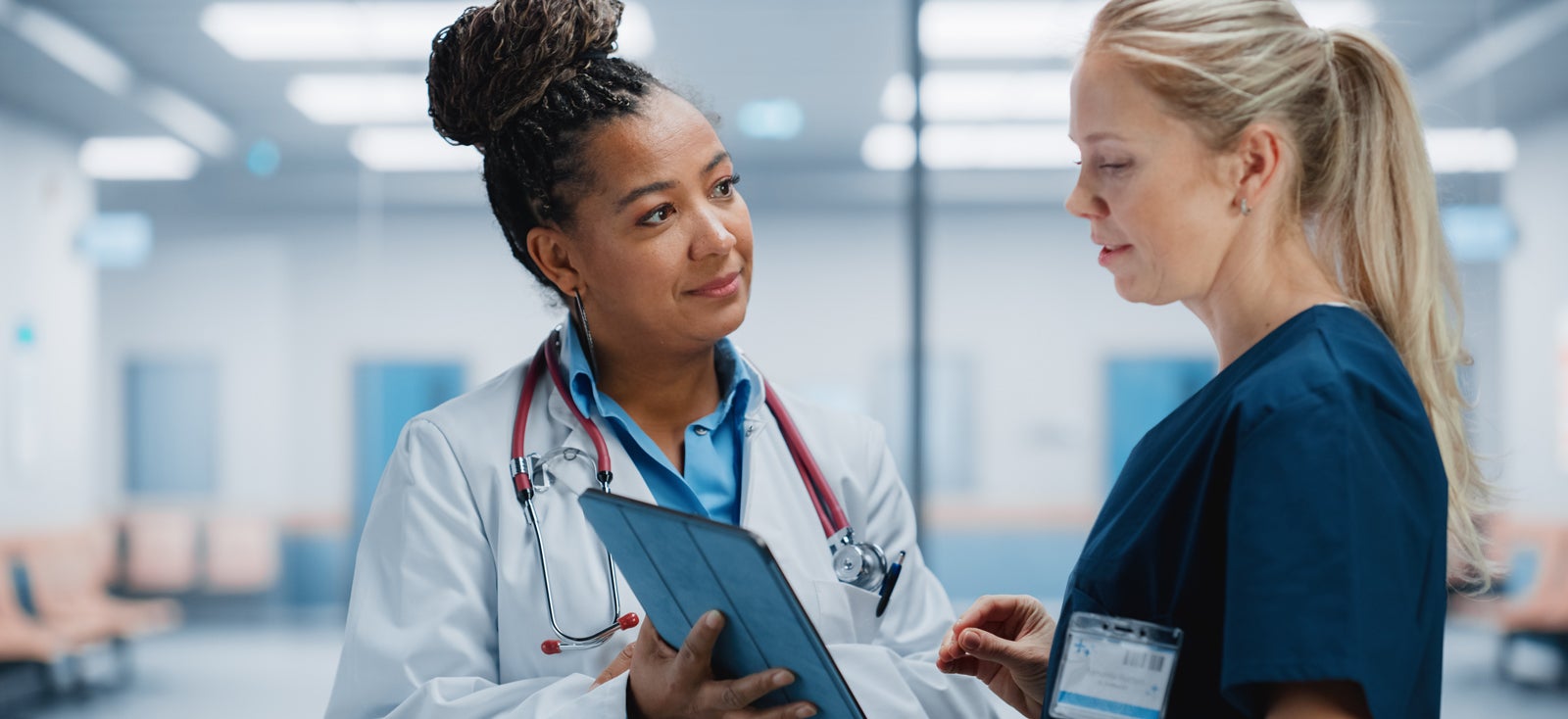 Managed Service Organization and Value Based Care Performance. CMS. Doctor showing a woman information on an iPad. Value-Based Care Performance.
